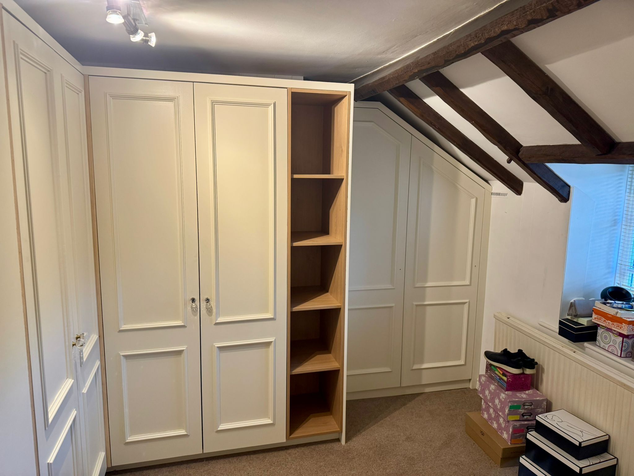 Fitted wardrobe built around roofing timbers