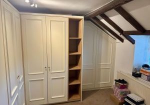 Fitted wardrobe built around roofing timbers